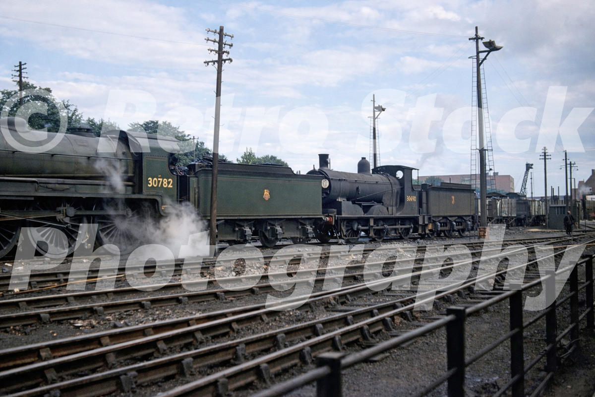 1950s view of King Arthur Class N15 No. 30782 at Bournemouth with steam drifting across sidings and yard tracks