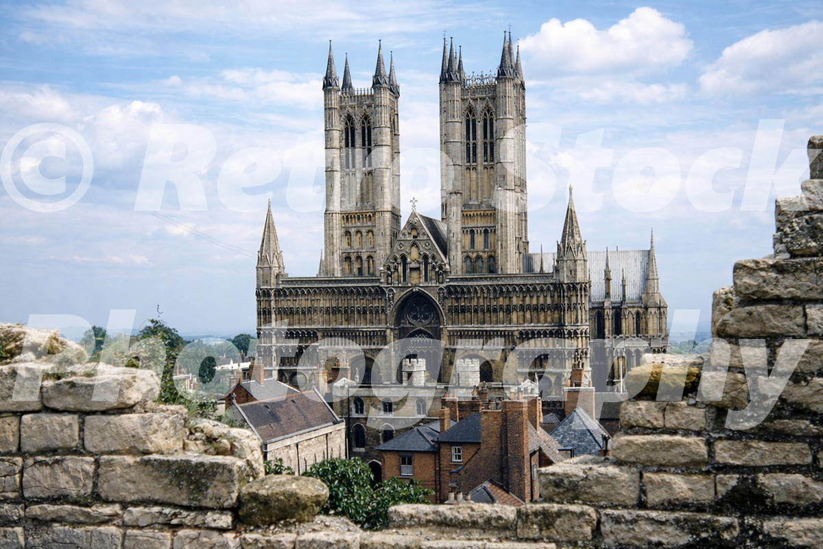 1950s colour photograph of Lincoln Cathedral seen from Lincoln Castle walls, showing the twin towers rising above the historic city rooftops.