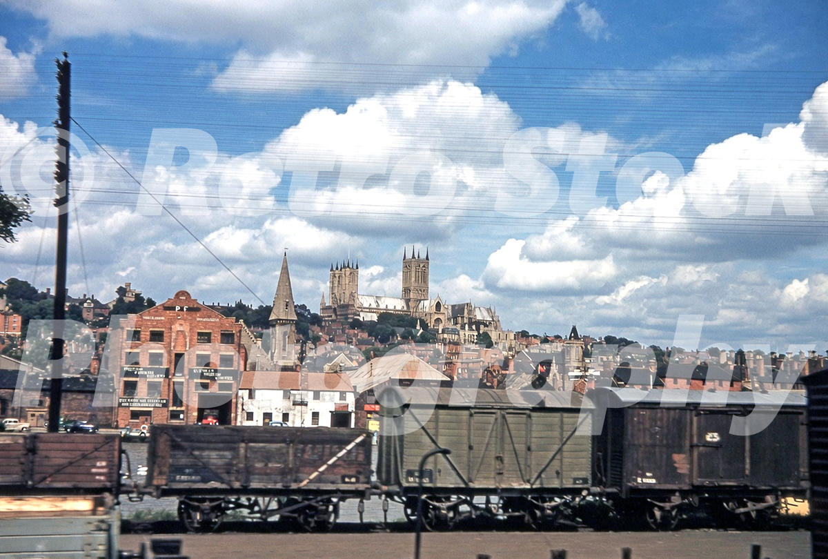 1950s view of Lincoln Cathedral in Lincolnshire above railway wagons, goods yard buildings and telegraph wires