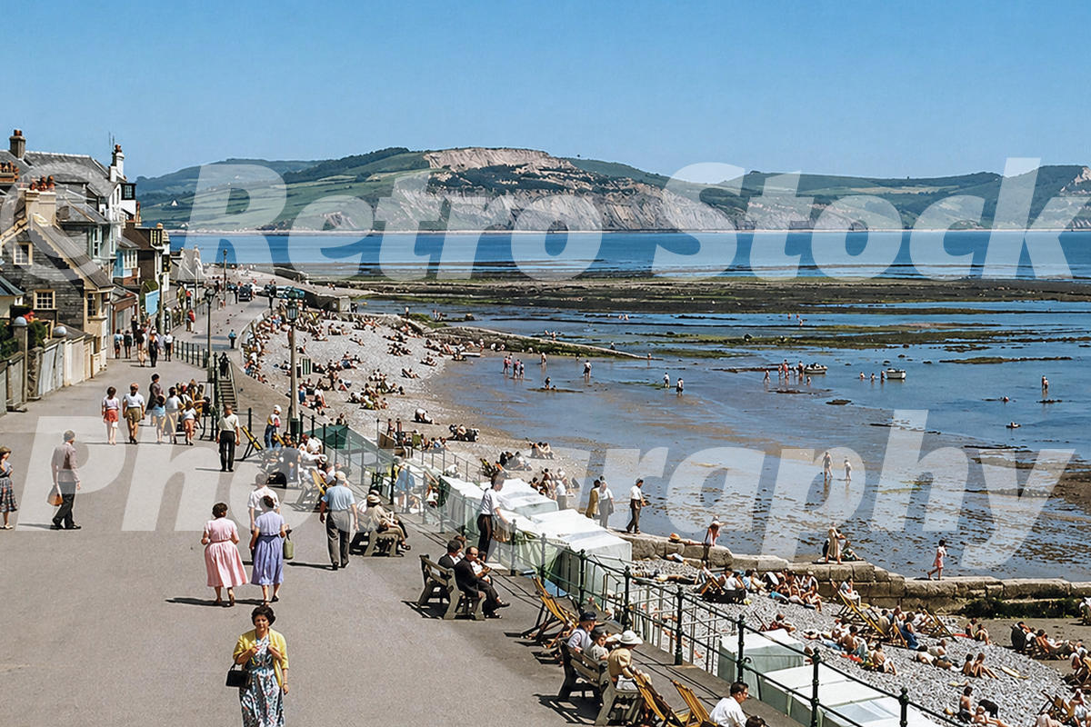 Lyme Regis seafront in the 1950s showing Marine Parade, holidaymakers, benches and a busy beach at low tide