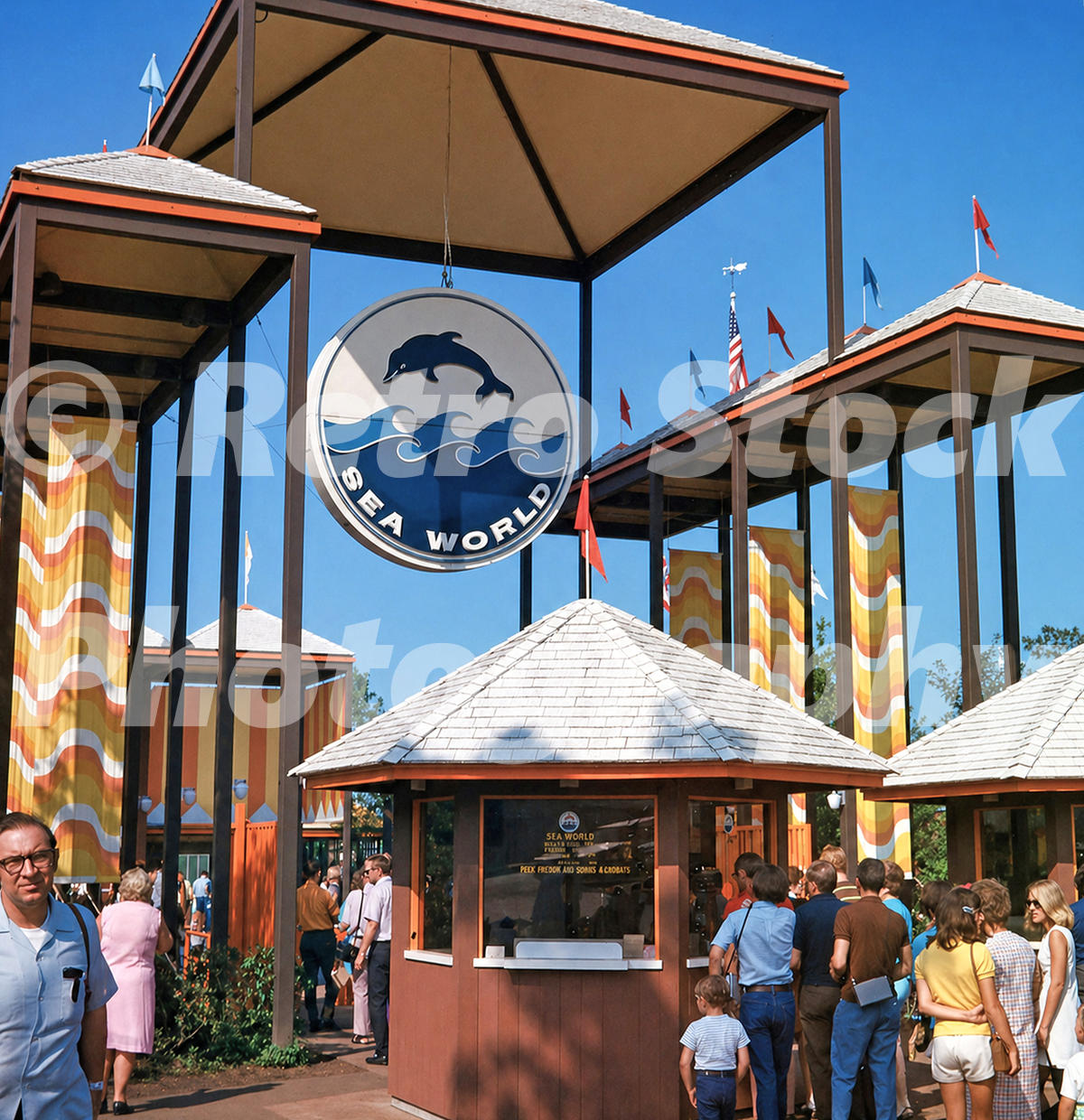 1970s color view of the main entrance to SeaWorld Ohio in Aurora, with the Sea World dolphin sign, ticket booths, flags and visitors.