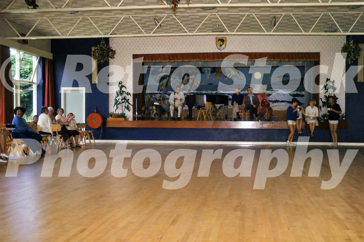 1960s view of the ballroom and stage at Pontins Dolphin Holiday Camp in Brixham, with holidaymakers, entertainers and a wooden dance floor.