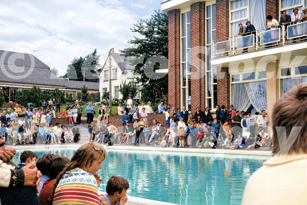 Pontins South Devon Holiday Camp outdoor pool at Paignton in the 1960s with large crowd, stepped terraces and modern poolside building