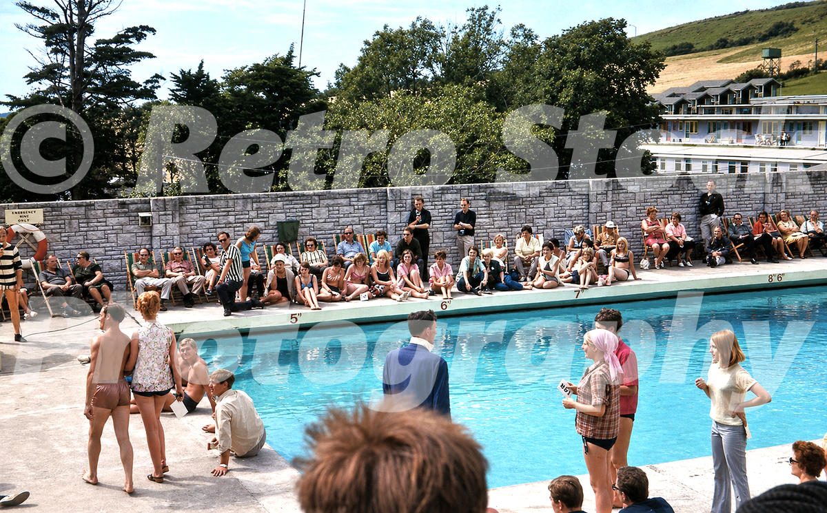 Pontins Osmington Bay outdoor pool near Weymouth in the 1960s with spectators, depth markings, deckchairs and a poolside event