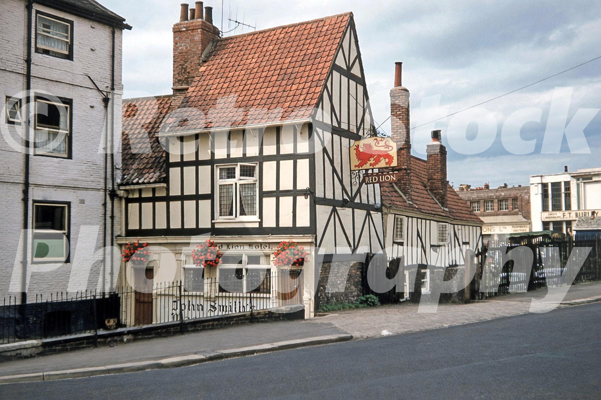 1950s view of The Red Lion on Walmgate in York, with timber-framed frontage, red tiled roof and hanging pub sign.