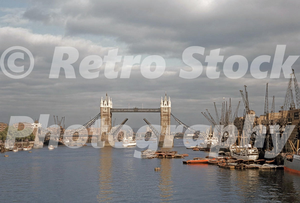 river-thames-london-1957_55230830052_o 1950s view of Tower Bridge raised over the Pool of London, with cranes, barges, ships and working wharves along the River Thames.
