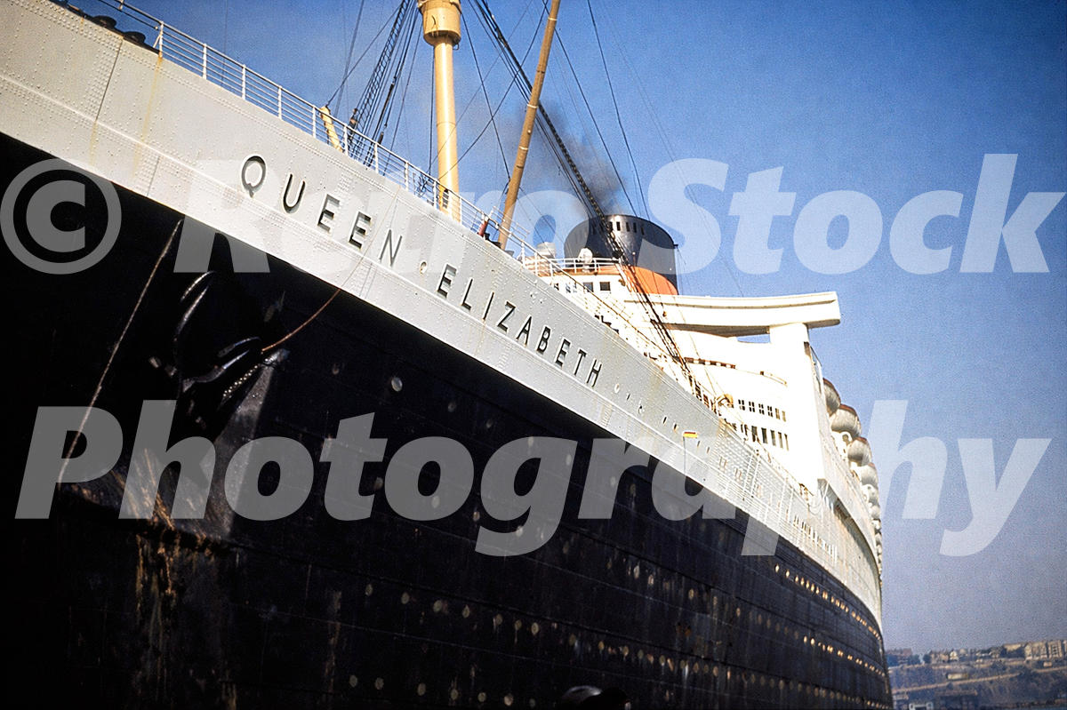 1950s view of RMS Queen Elizabeth at Southampton, showing the liner’s name, black hull, portholes and Cunard funnel.