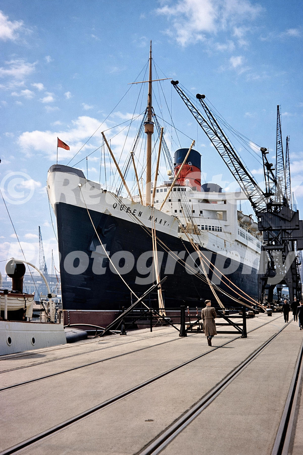 RMS Queen Mary at Southampton docks in 1950 showing the liner alongside the quay with cranes and dockside railway tracks