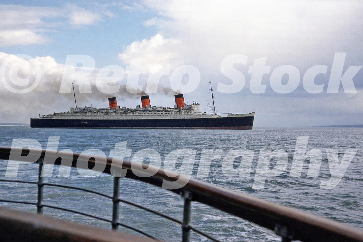RMS Queen Mary sailing along the south coast of England in 1950, viewed from a promenade or pier railing