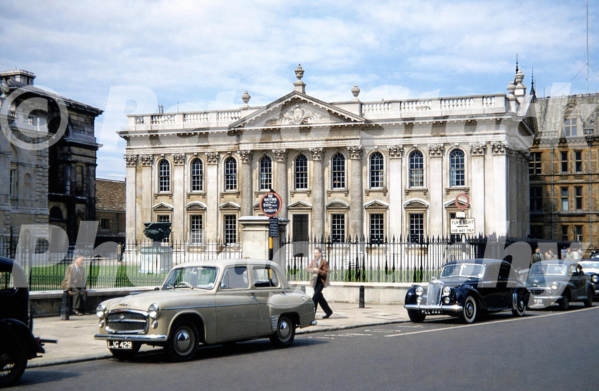 Senate House on King’s Parade in Cambridge in the 1950s showing the neo-classical building, parked cars and pedestrians