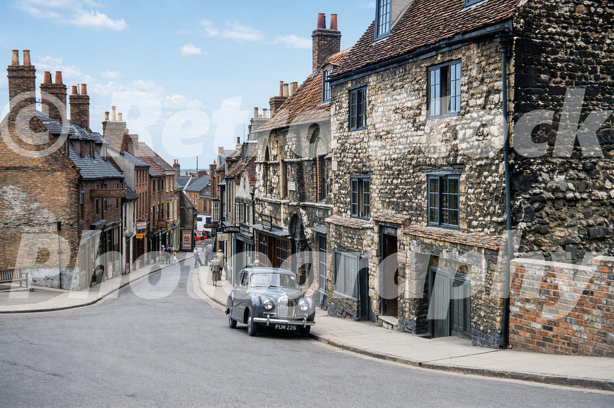 Lower end of Steep Hill in Lincoln in the 1950s with historic stone buildings and an Austin A40 Somerset car