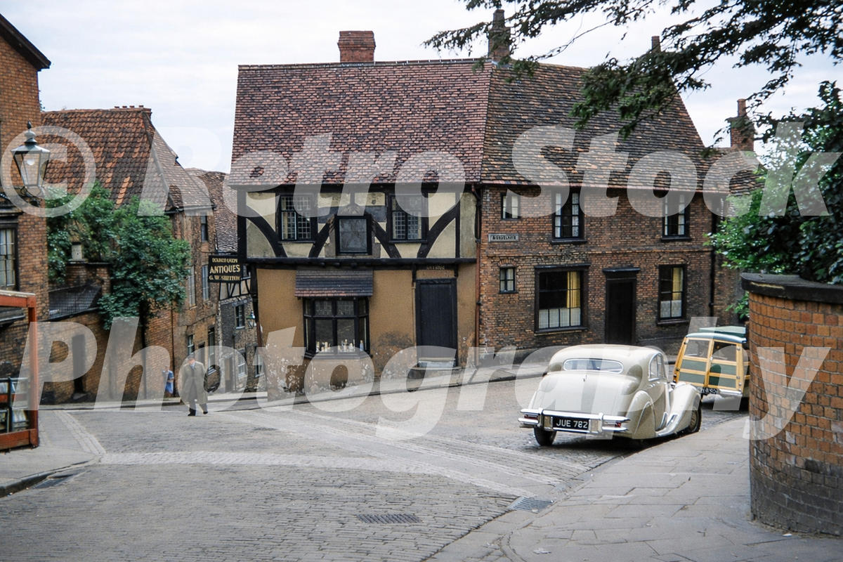 Steep Hill in Lincoln in 1956 showing historic timber-framed buildings and a Jaguar Mk V on the narrow street