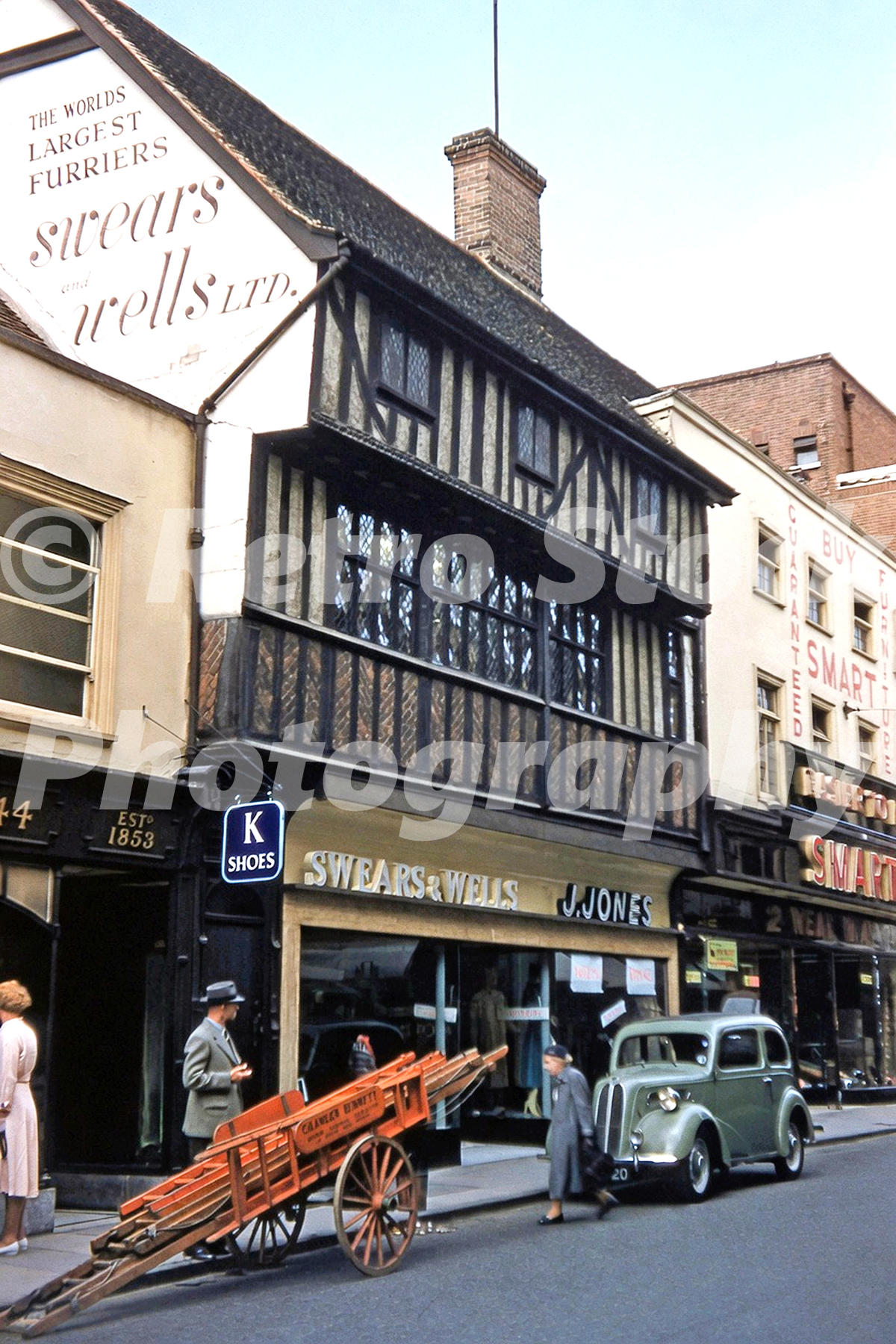 Swears and Wells furriers on the Buttermarket in Ipswich in 1956 showing a timber-framed shop, a Ford Popular car and handcart