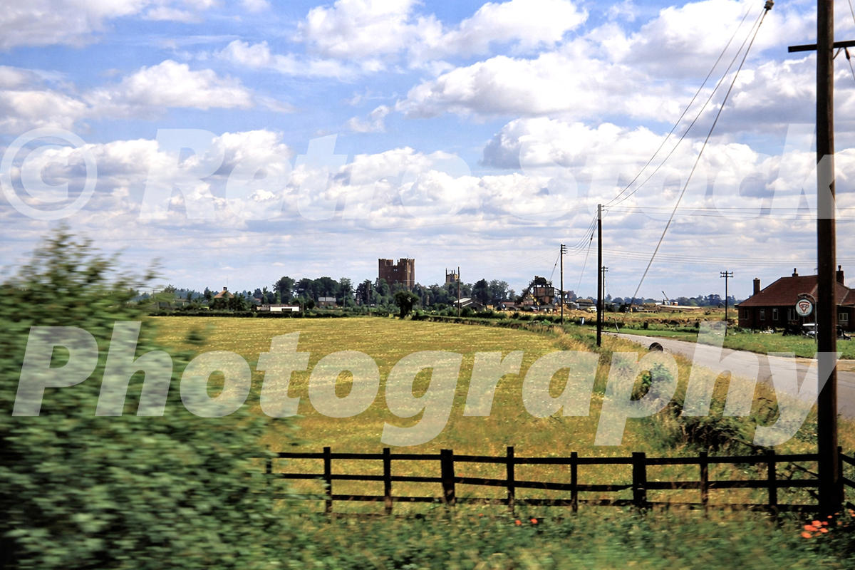 1950s view of Tattershall Castle in Lincolnshire seen from a passing train near the A153 Sleaford Road level crossing.