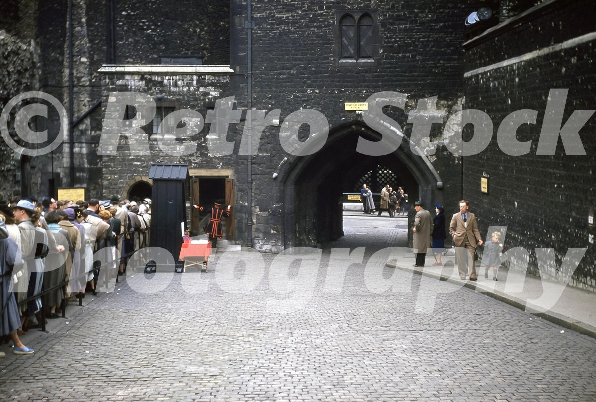 tower-of-london-1956_55230830522_o 1950s colour photo of visitors outside the Bloody Tower at the Tower of London, with a Yeoman Warder, cobbled roadway and stone gateway.