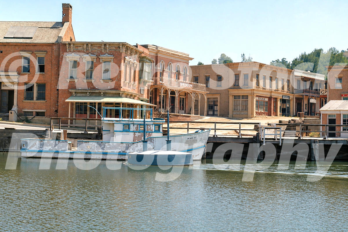 Western-style waterfront backlot set at Universal Studios Hollywood in the 1970s, with a boat, dock, saloon, bank and sheriff buildings.