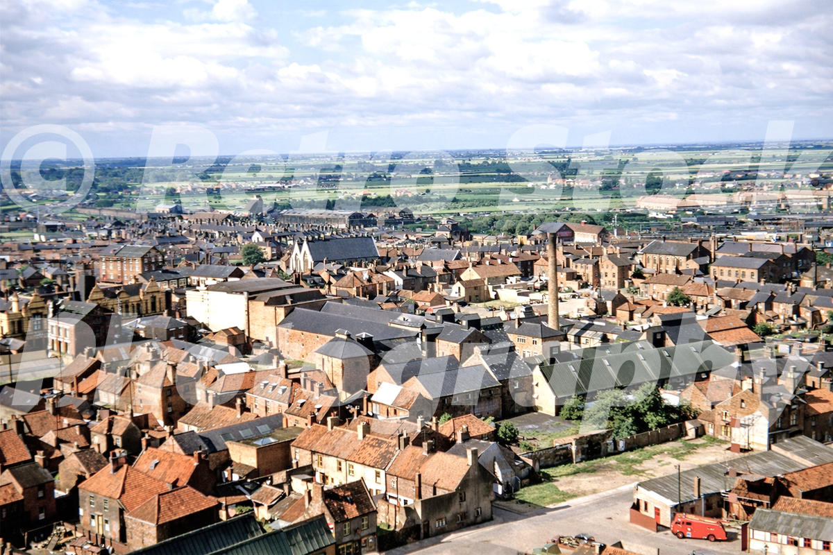 1950s colour photo of Boston, Lincolnshire, seen from St Botolph’s Church tower, with rooftops, warehouses, chimneys and fenland countryside beyond.