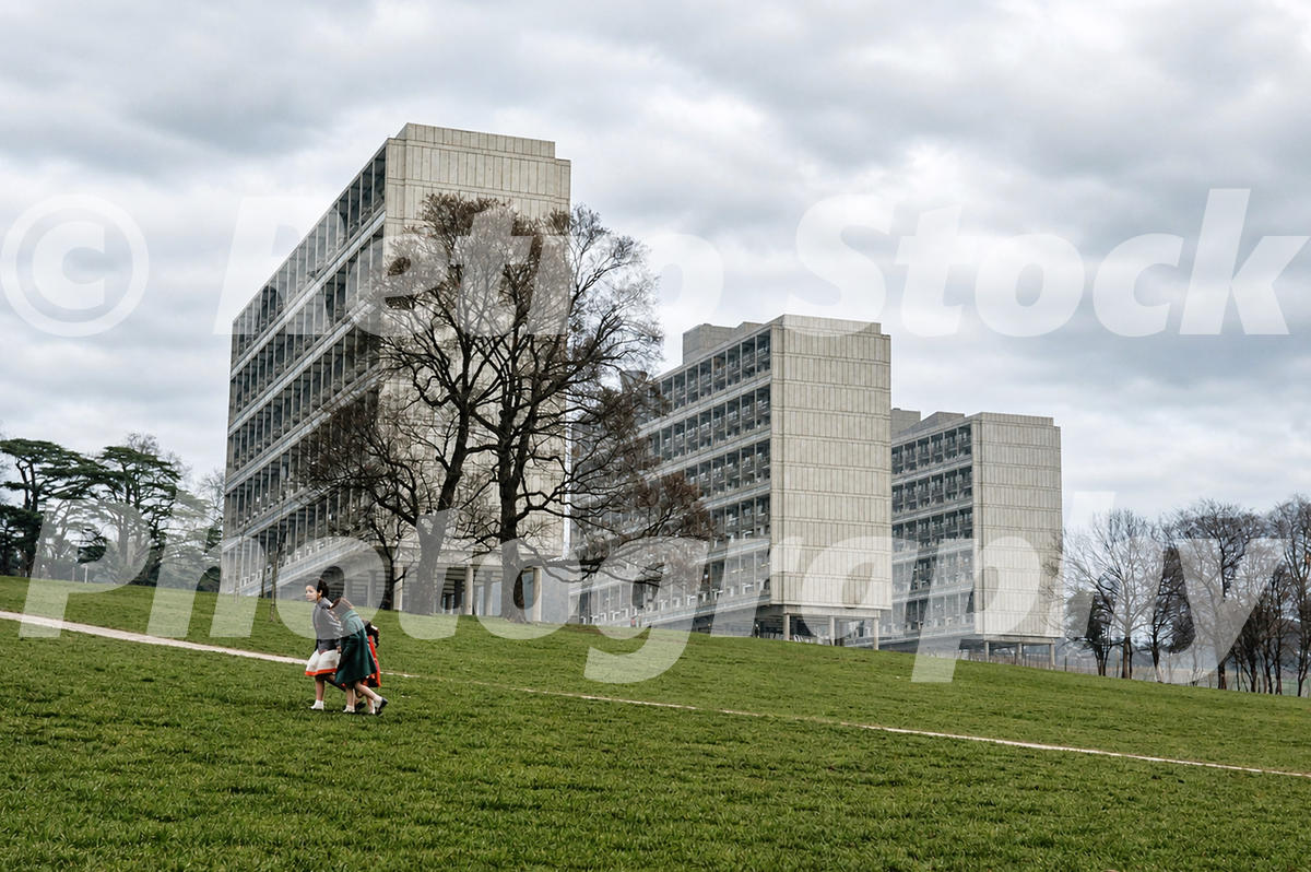 1960s view of modernist slab blocks on the Alton Estate in Roehampton, London, with open grass, bare trees and pedestrians.