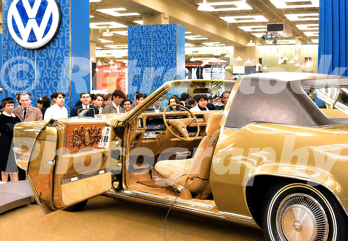 A 1960s color photo of the driver-side door and interior of a Cadillac Eldorado on display at the 1968 New York Auto Show, showing the ornate door panel and woodgrain trim.