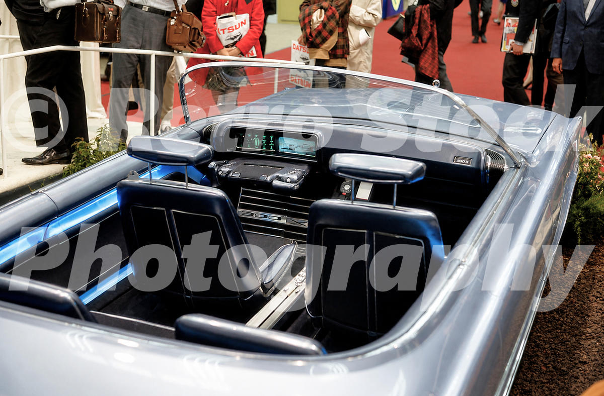 A 1960s color photo of the interior of the Chrysler 300X concept car at the 1966 New York Auto Show, showing the joystick steering and digital-style dash.