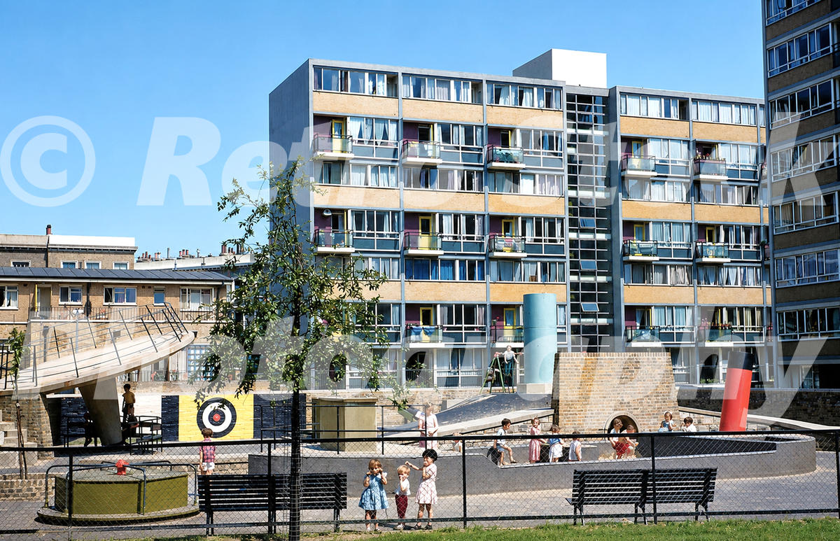 churchill-gardens-estate-pimlico-1950s_55260681201_o A 1950s colour photo of the Churchill Gardens Estate in Pimlico, London, featuring a modernist playground with a concrete slide and children playing in front of high-rise residential blocks.