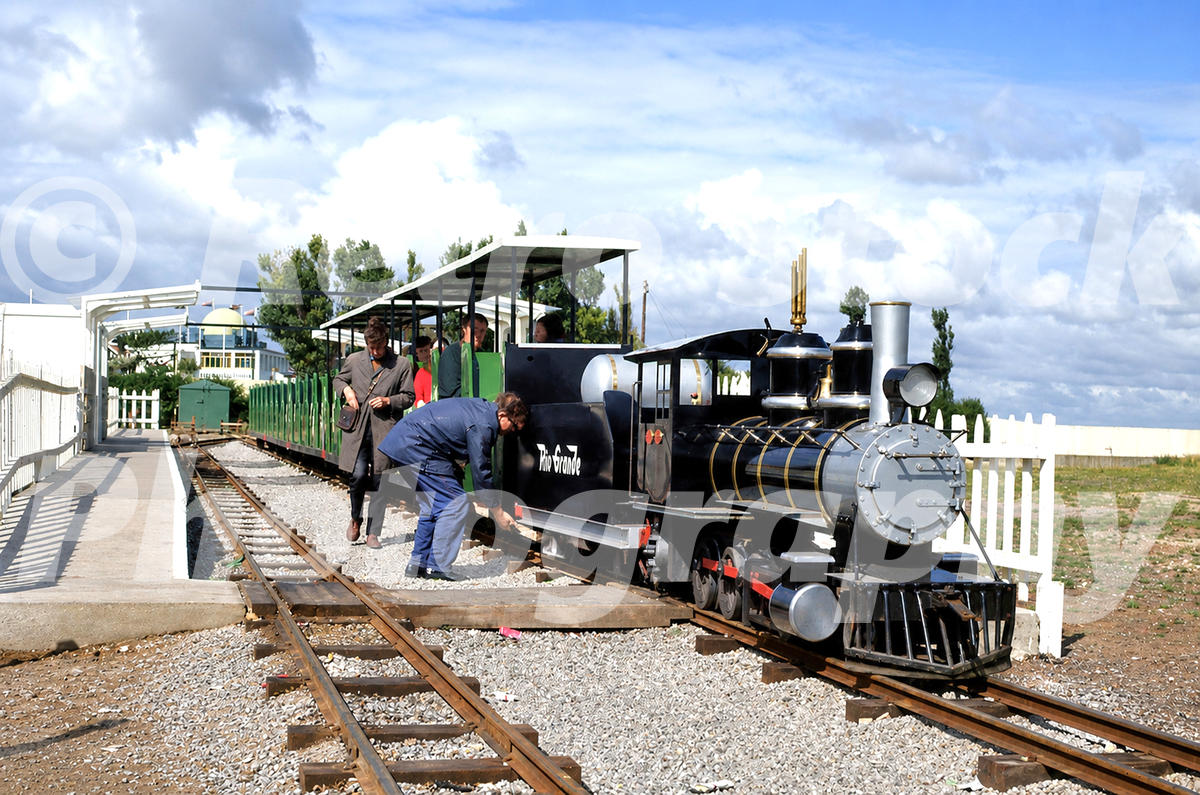 1970s view of a Severn Lamb Rio Grande locomotive at Cleethorpes Miniature Railway, waiting in the station with open carriages and passengers.