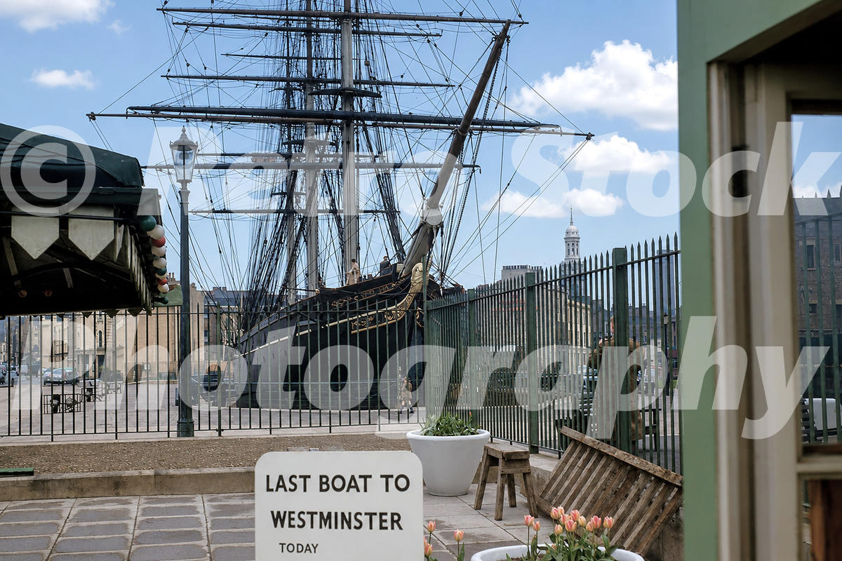 A 1950s colour photo of the tea clipper Cutty Sark in its dry dock at Greenwich, viewed from a terrace with a sign reading "LAST BOAT TO WESTMINSTER TODAY".