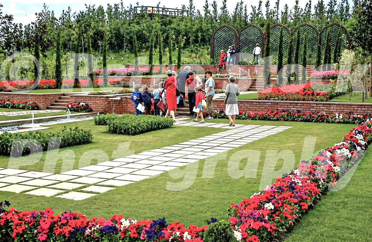 1980s photo of the Liverpool Garden Festival with formal lawns, flower beds, fountains and visitors walking through the gardens.