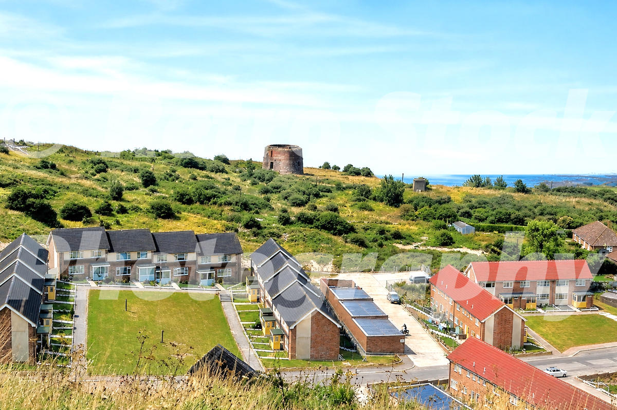 1970s view of Folkestone, Kent, with modern hillside housing, the sea in the distance and a Martello tower on the ridge.