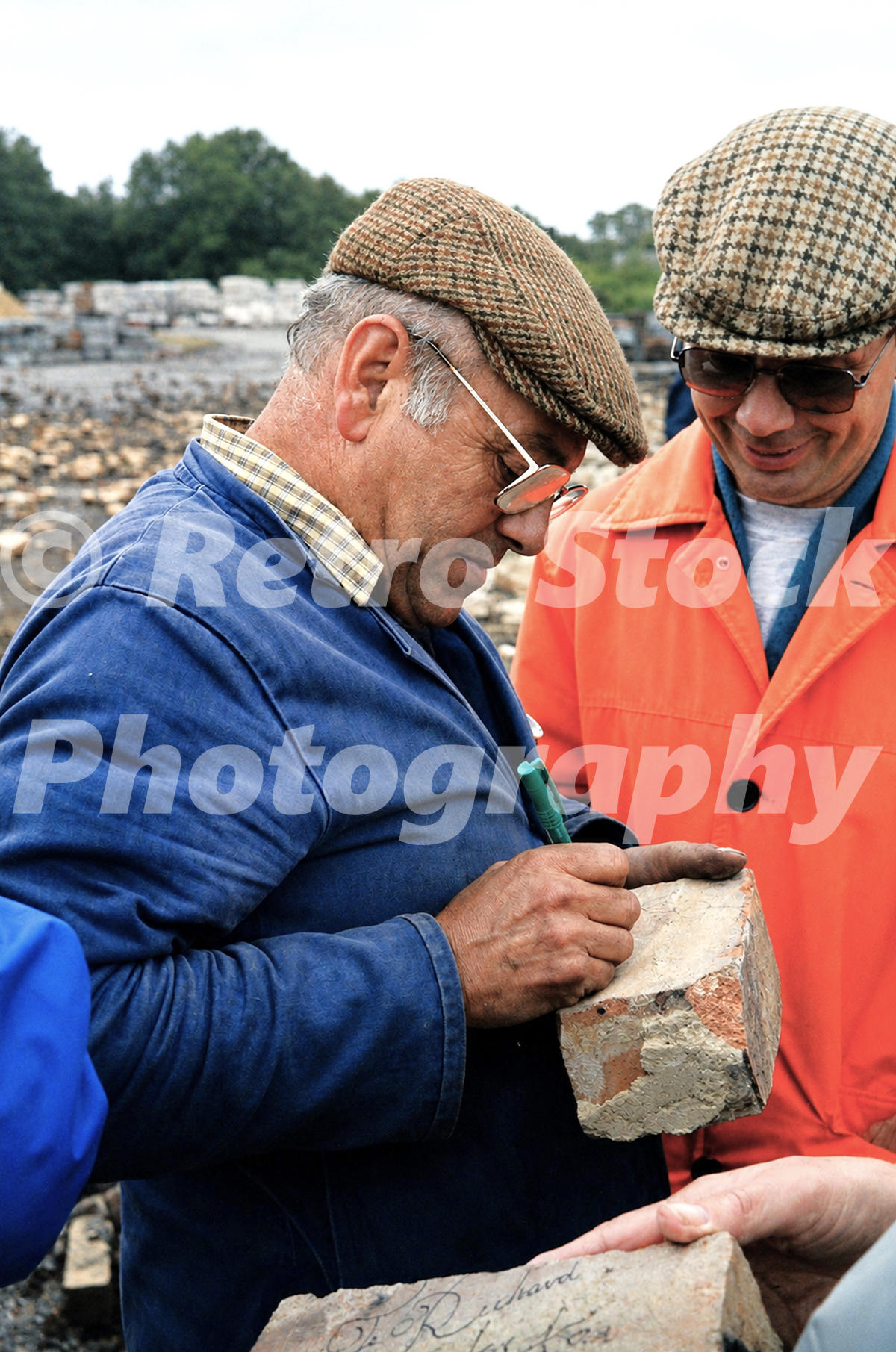 1980s close-up view of Fred Dibnah signing a brick after demolishing a chimney at the Redland Roof Tile factory in Leighton Buzzard.