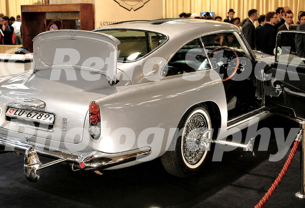 A 1960s colour photo of the silver James Bond Aston Martin DB5 from Goldfinger at the 1965 New York Auto Show, showing the bulletproof shield and tyre slasher.