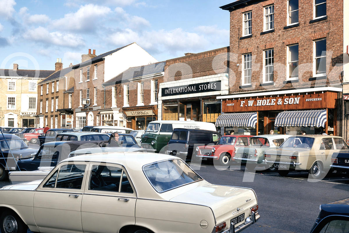 A 1970 photograph of Market Place in Long Sutton, Lincolnshire, showing International Stores, F.W. Hole & Son butchers, and numerous parked period cars.