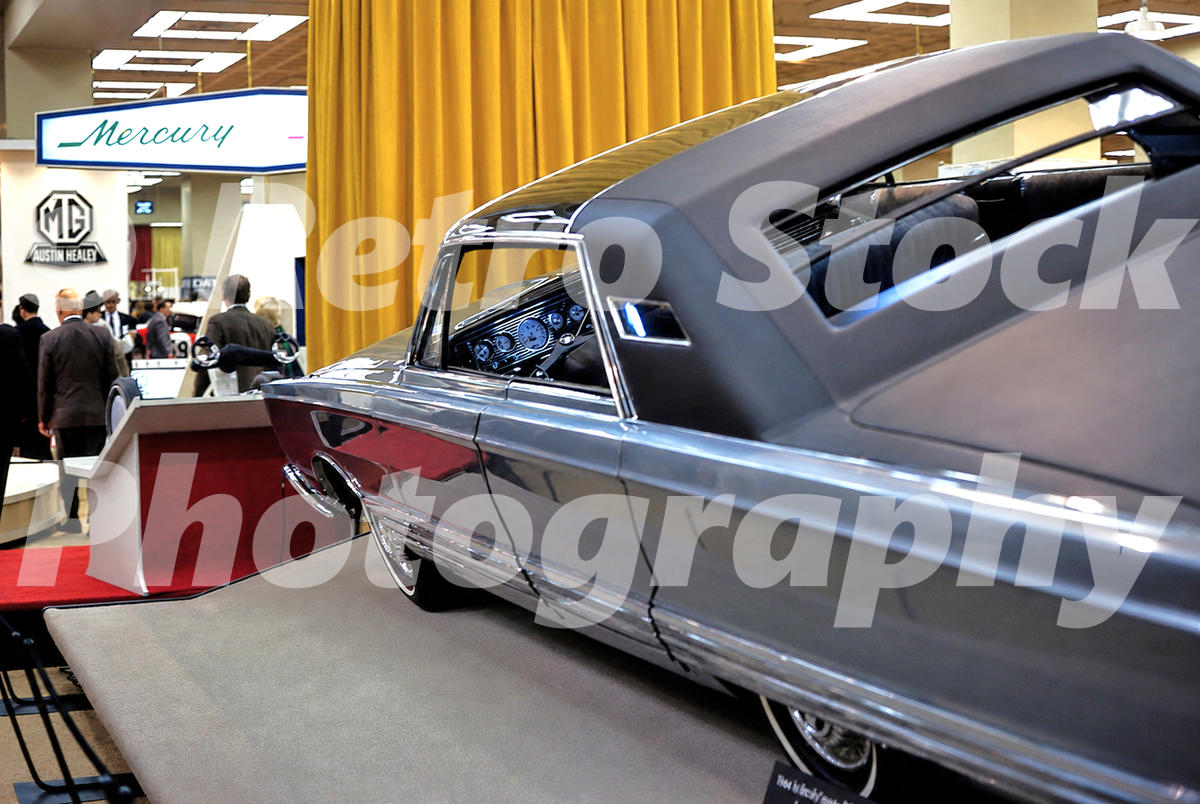 A 1960s color photo of the Mercury Astron concept car at the 1966 New York Auto Show, featuring a sun-sensitive glass roof and a sleek blue exterior.