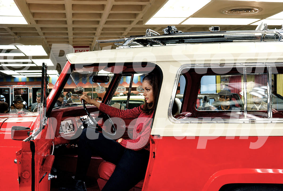 A 1960s color photo of a woman in a red sweater sitting in a red and white Jeep Commando at the 1968 New York Auto Show.