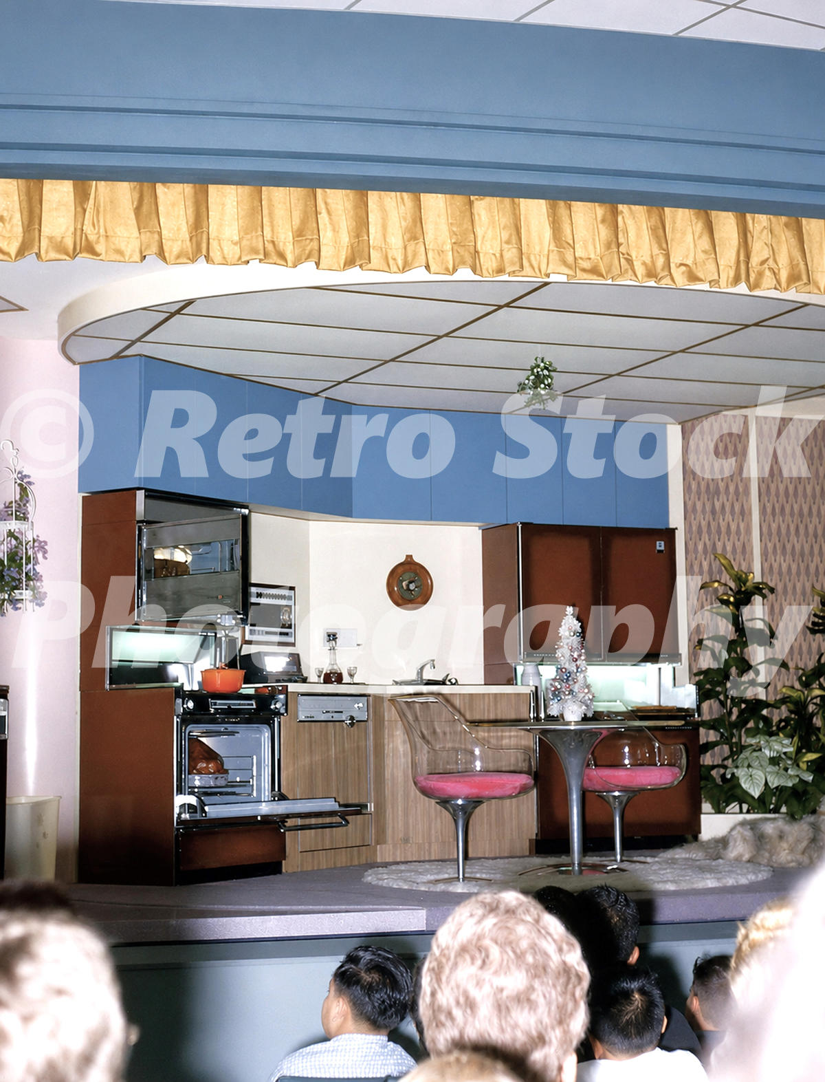 1960s color view inside the Progressland Theatre at the GE Pavilion, New York World’s Fair, showing a Carousel of Progress kitchen scene and seated audience.