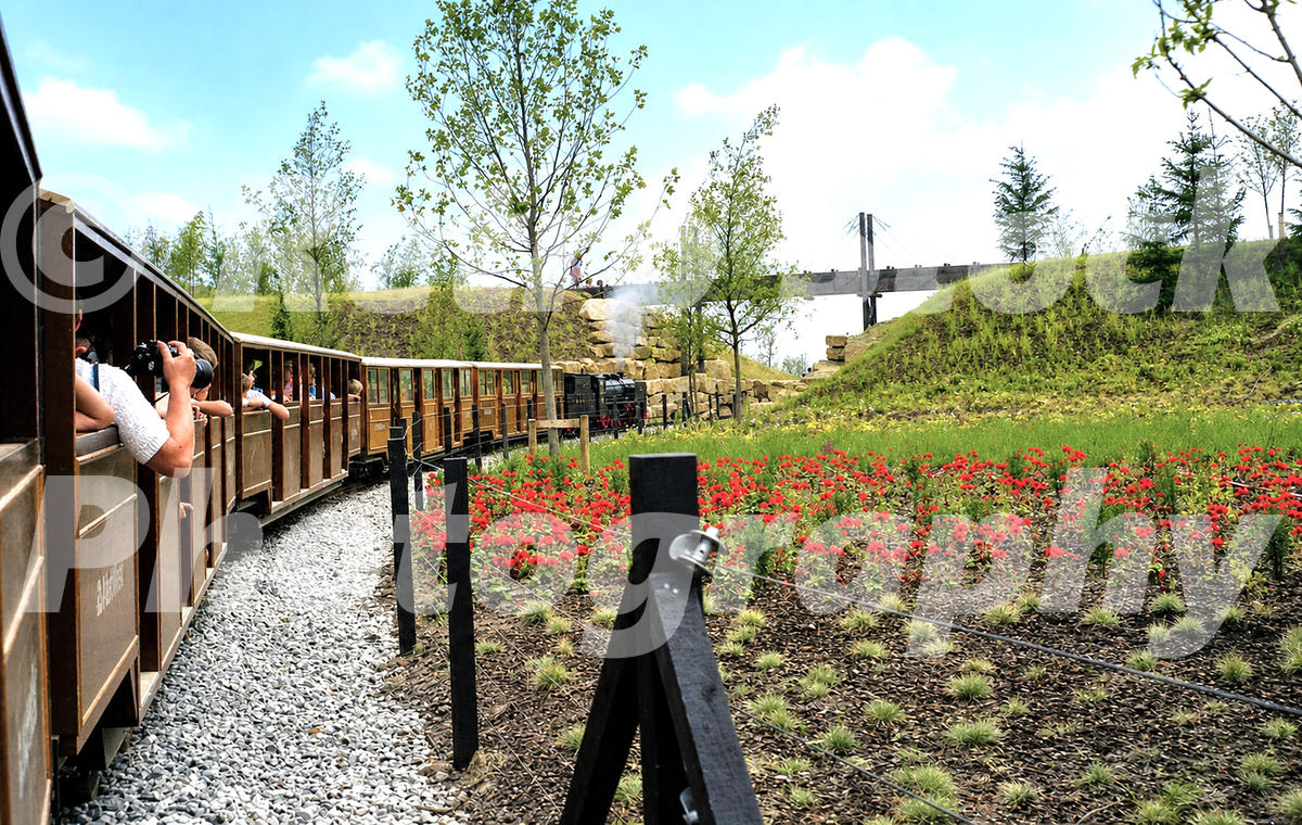 1980s view of the railway at the Liverpool Garden Festival, with a miniature passenger train running through landscaped grounds and flower beds.