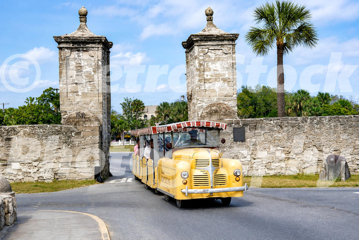 road-train-at-st-augustine-florida-1960_55259781127_o 1960s color view of a yellow sightseeing road train passing through the Old City Gates in St. Augustine, Florida, with stone walls, palm trees and a cannon.