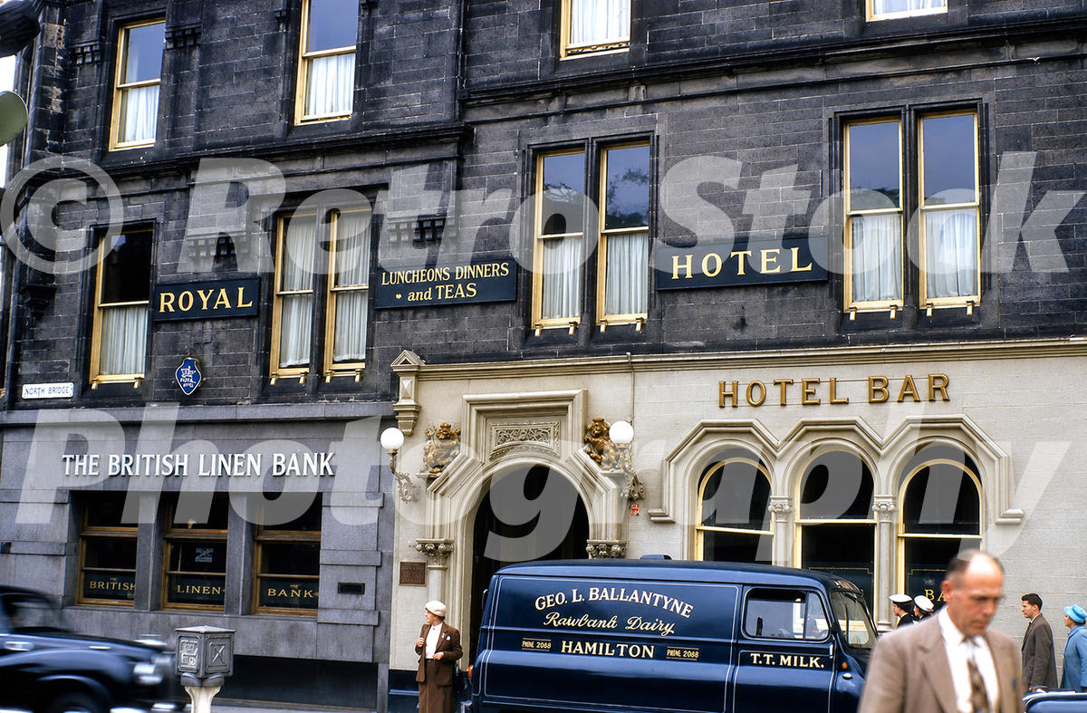 1950s view of the Royal Hotel on Quarry Street in Hamilton, Scotland, with the British Linen Bank, a Railbrand Dairy milk van, pedestrians and traffic.