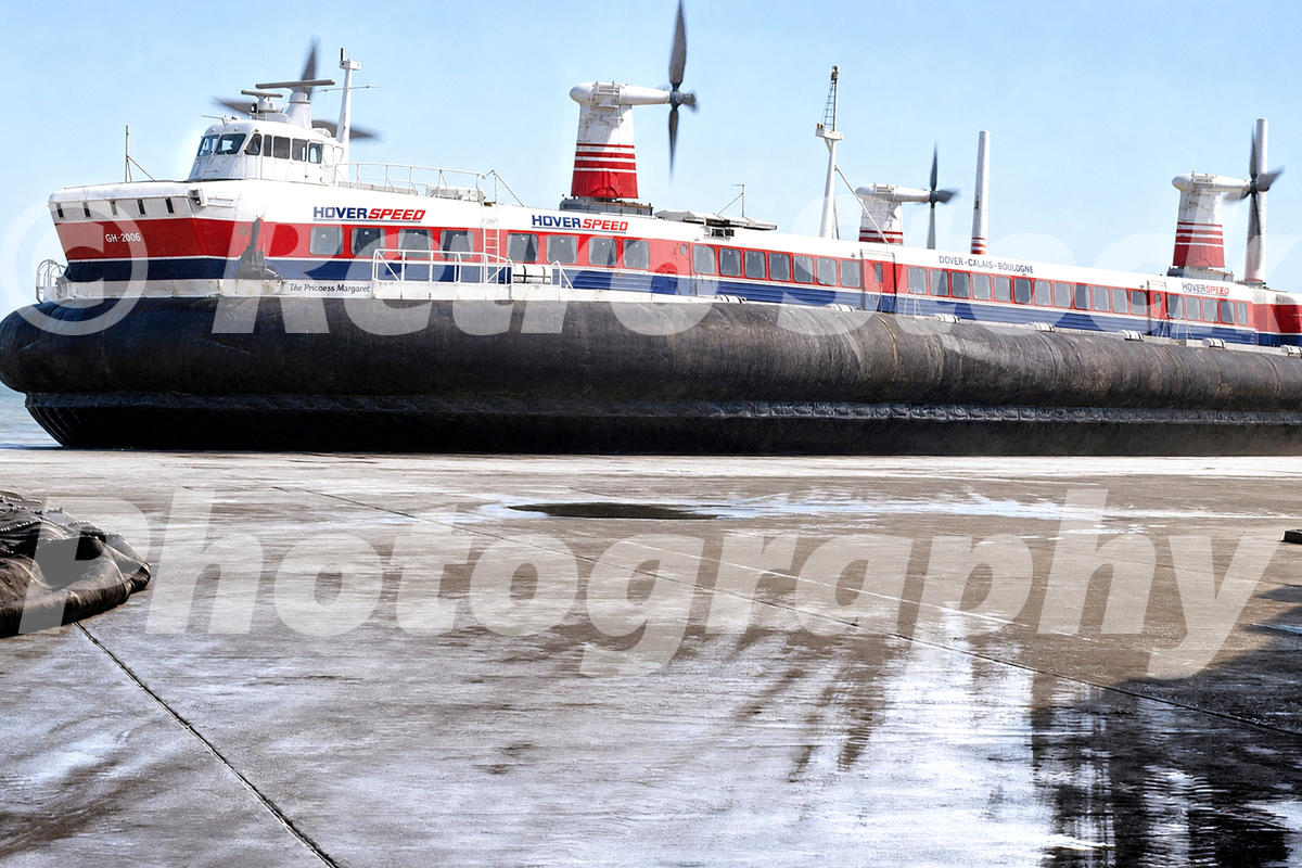 A 1980s photograph of the SR.N4 hovercraft The Princess Margaret at Dover, showing the vessel in the red, white, and blue Hoverspeed livery with its large black rubber skirts fully inflated on the concrete pad.